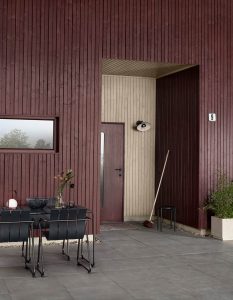 Mørkerødt hus i fargen Jotun 2279 Dodenkopf med detaljer i 1283 Lys grå Umbra