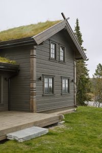 Tradisjonell laftet hytte med gress på taket, beiset med Jotun TREBITT Matt Oljebeis i 9061 Jernvitrol